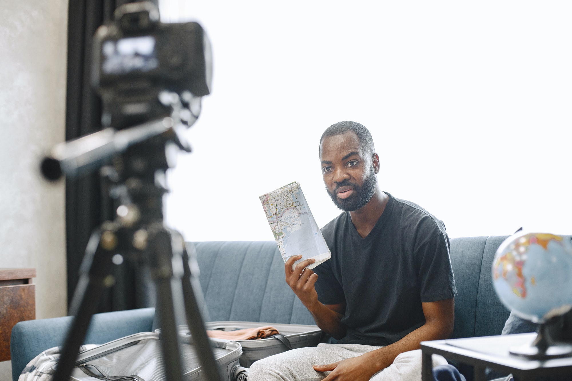 African male blogger recording vlog on digital camera