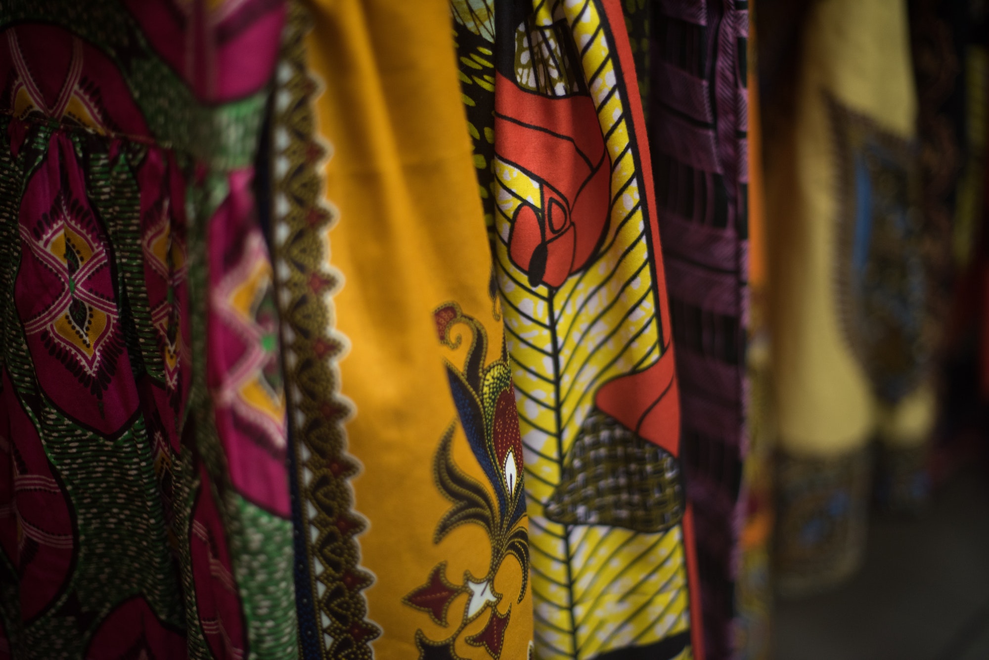Close up shot on colorful African print dresses hanging on rack